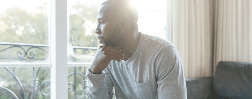 man staring out of window