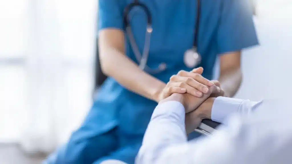 Navigating the Teen Years: How Long Does Addiction Linger? 6 Nurse with a stethoscope holds a patient’s hands.