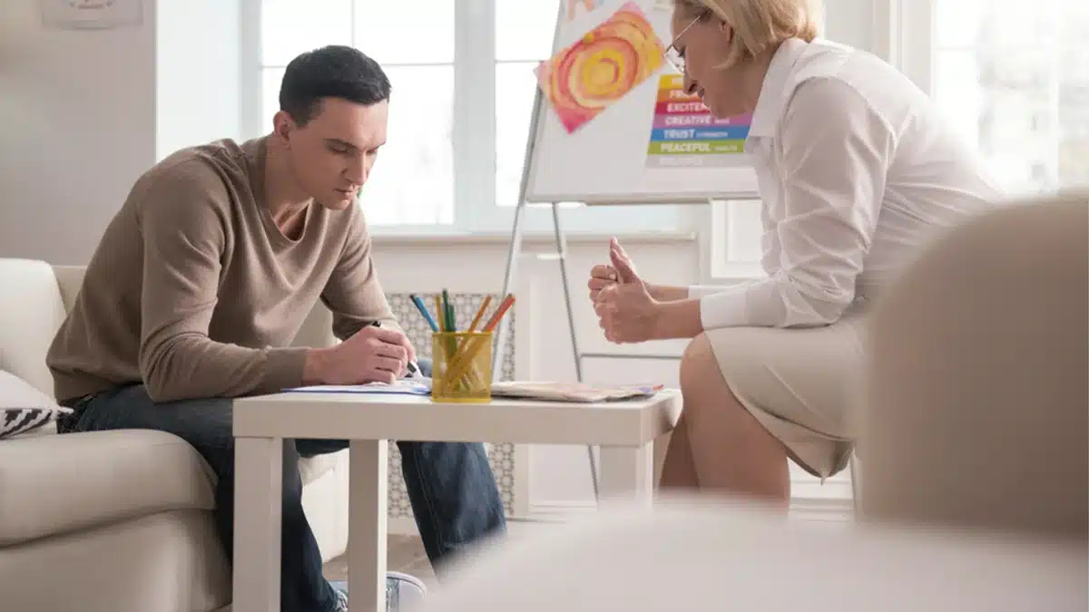 Teen boy drawing with colored pencils. Text explains art therapy addresses various health issues, offering a unique healing approach.