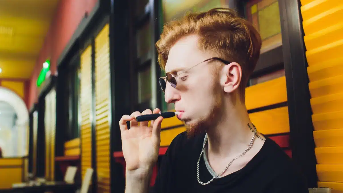 teenager vaping with sunglasses on