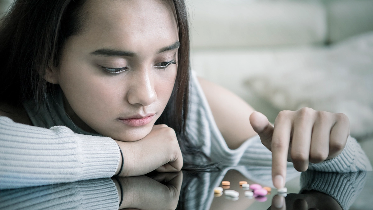 Teenage playing with a multi color assortment of pills