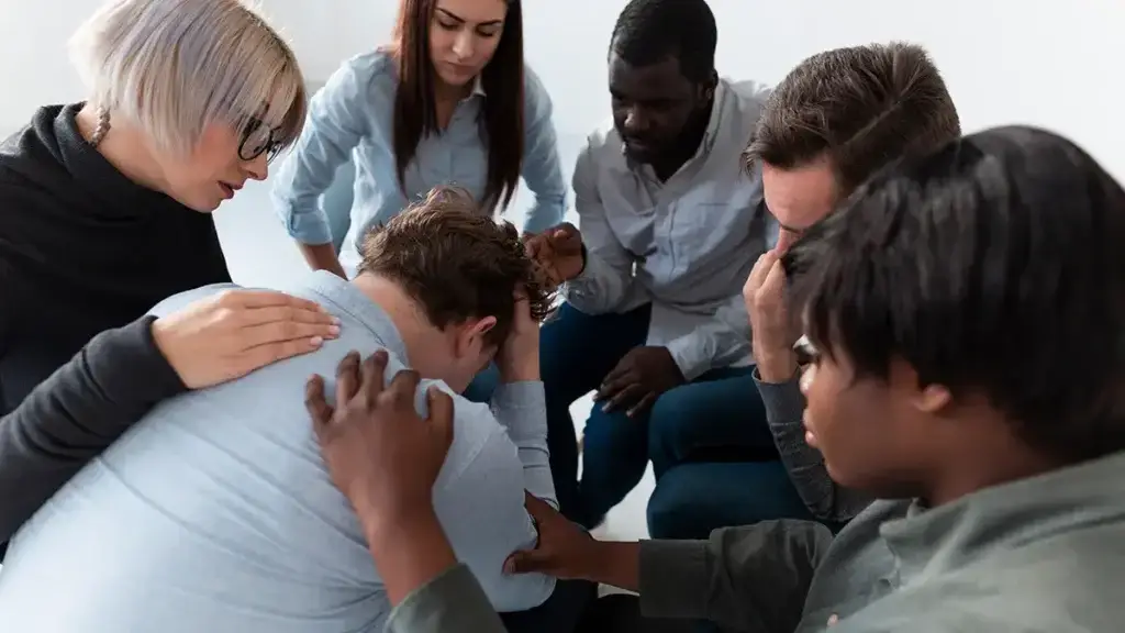 Impact Of Youth Addiction Programs 5 A diverse group of young people engaged in a supportive counseling session.
