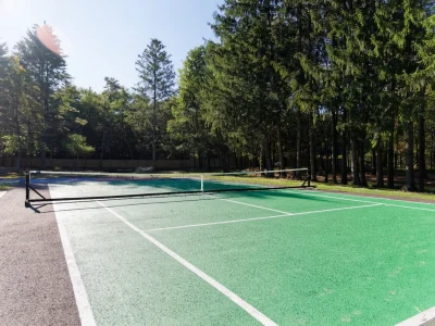 Outdoor recreational area at Never Alone rehab facility with tennis court